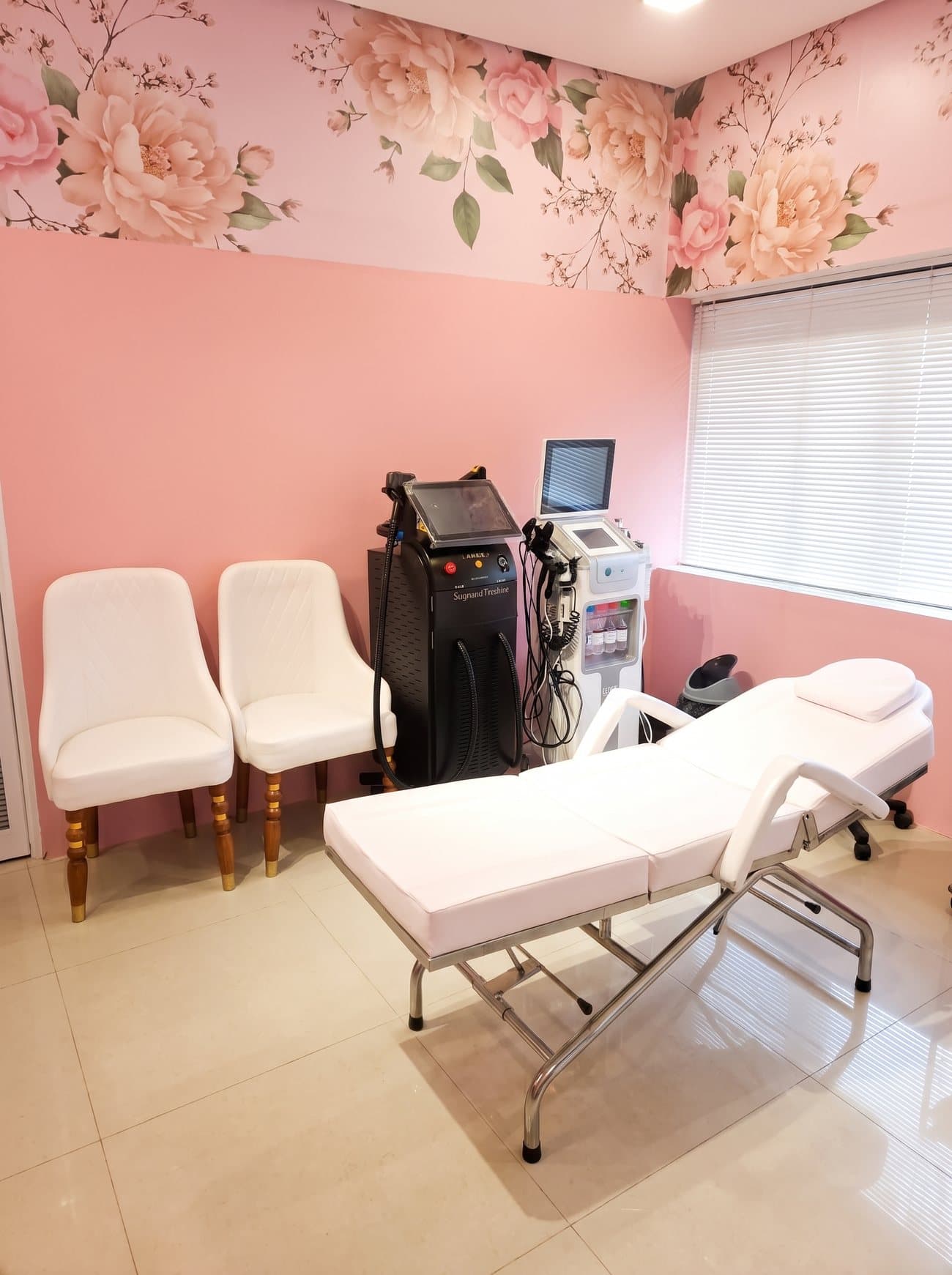 The private treatment room at Prism Aesthetics, with a treatment bed and laser equipment